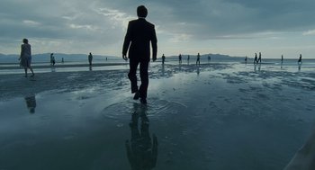 Movie still from “The Tree of Life” (2011), directed by Terrence Malick – A group of people standing on top of a wet beach; Extreme Wide shot, High angle