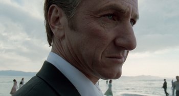 Movie still from “The Tree of Life” (2011), directed by Terrence Malick – A person wearing a suit near the ocean; Close Up shot, Low angle