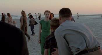 Movie still from “The Tree of Life” (2011), directed by Terrence Malick – A group of people walking on the beach at sunset; Medium shot, Over the shoulder angle