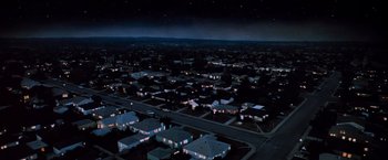 Movie still from “Close Encounters of the Third Kind” (1977), directed by Steven Spielberg – An aerial view of a neighborhood at night; Extreme Wide shot, High angle