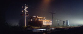 Movie still from “Close Encounters of the Third Kind” (1977), directed by Steven Spielberg – An old school bus parked on the side of the road at night; Extreme Wide shot, Low angle