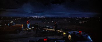 Movie still from “Close Encounters of the Third Kind” (1977), directed by Steven Spielberg – A group of people standing on top of a hill at night; Extreme Wide shot, High angle