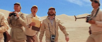 Movie still from “Close Encounters of the Third Kind” (1977), directed by Steven Spielberg – Two men are walking in the desert with a camera; Medium shot, Low angle