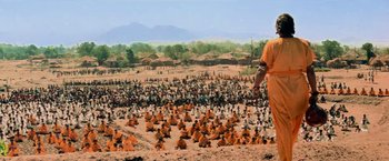 Movie still from “Close Encounters of the Third Kind” (1977), directed by Steven Spielberg – An image of a man standing in front of a large group of people; Extreme Wide shot, High angle