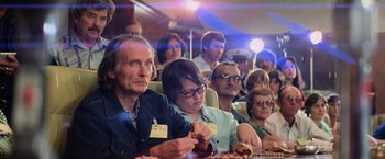 Movie still from “Close Encounters of the Third Kind” (1977), directed by Steven Spielberg – A group of people sitting around a table; Medium shot, Over the shoulder angle