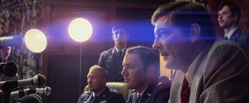 Movie still from “Close Encounters of the Third Kind” (1977), directed by Steven Spielberg – A group of men sitting next to each other in front of a light; Medium shot, Low angle