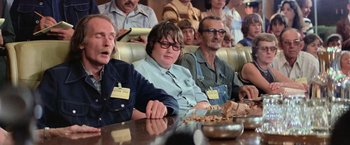 Movie still from “Close Encounters of the Third Kind” (1977), directed by Steven Spielberg – A group of people sitting at a table with food; Medium shot, Over the shoulder angle