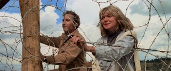Movie still from “Close Encounters of the Third Kind” (1977), directed by Steven Spielberg – A man and a woman standing next to a barbed wire fence; Medium shot, Low angle