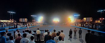 Movie still from “Close Encounters of the Third Kind” (1977), directed by Steven Spielberg – A group of people standing in front of an arena; Extreme Wide shot, High angle