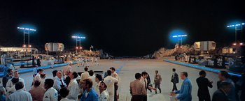 Movie still from “Close Encounters of the Third Kind” (1977), directed by Steven Spielberg – A group of people standing on top of a dirt field; Extreme Wide shot, High angle