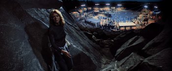 Movie still from “Close Encounters of the Third Kind” (1977), directed by Steven Spielberg – A woman standing on top of a mountain near a city; Wide shot, High angle