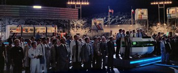 Movie still from “Close Encounters of the Third Kind” (1977), directed by Steven Spielberg – A group of men in suits and ties standing in a parking lot at night; Extreme Wide shot, Low angle