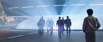 Movie still from “Close Encounters of the Third Kind” (1977), directed by Steven Spielberg – A group of people standing in a room with lights; Wide shot, Low angle