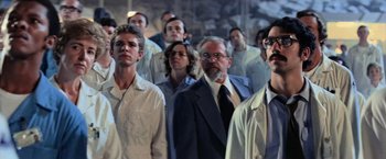 Movie still from “Close Encounters of the Third Kind” (1977), directed by Steven Spielberg – A large group of people standing in a room; Medium shot, Low angle