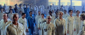 Movie still from “Close Encounters of the Third Kind” (1977), directed by Steven Spielberg – A large group of people in white lab coats; Wide shot, Low angle