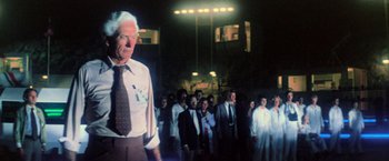 Movie still from “Close Encounters of the Third Kind” (1977), directed by Steven Spielberg – An old man standing in front of a group of people; Medium shot, Low angle