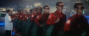 Movie still from “Close Encounters of the Third Kind” (1977), directed by Steven Spielberg – A group of men in red shirts and green aprons; Medium shot, Low angle