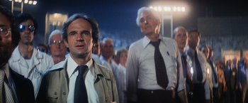 Movie still from “Close Encounters of the Third Kind” (1977), directed by Steven Spielberg – A group of men standing next to each other in a crowd; Medium shot, Low angle