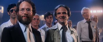 Movie still from “Close Encounters of the Third Kind” (1977), directed by Steven Spielberg – A group of men standing next to each other in a room; Close Up shot, Low angle