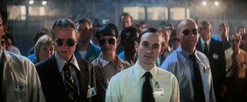 Movie still from “Close Encounters of the Third Kind” (1977), directed by Steven Spielberg – A group of people standing in front of each other wearing ties; Medium shot, Over the shoulder angle