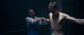 Movie still from “Clouds” (2020), directed by Justin Baldoni – A man in a blue apron and a man in a white shirt; Medium shot, Low angle