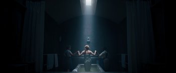 Movie still from “Clouds” (2020), directed by Justin Baldoni – A woman sitting in a bath tub in a dark room; Wide shot, Overhead angle