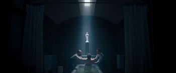 Movie still from “Clouds” (2020), directed by Justin Baldoni – Three people sitting in a dark room holding hands; Wide shot, Low angle