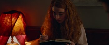 Movie still from “Clouds” (2020), directed by Justin Baldoni – A woman with long red hair writing in a notebook; Close Up shot, High angle