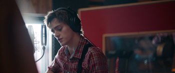 Movie still from “Clouds” (2020), directed by Justin Baldoni – A young man wearing headphones in a recording studio; Close Up shot, Over the shoulder angle
