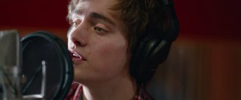 Movie still from “Clouds” (2020), directed by Justin Baldoni – A young man wearing headphones and a microphone; Extreme Close Up shot, Low angle