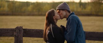 Movie still from “Clouds” (2020), directed by Justin Baldoni – A man and a woman kissing in front of a wooden fence; Close Up shot, Over the shoulder angle