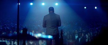 Movie still from “Clouds” (2020), directed by Justin Baldoni – A man standing in front of an audience on a stage; Wide shot, Over the shoulder angle