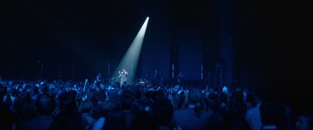 Movie still from “Clouds” (2020), directed by Justin Baldoni – A crowd of people in a dark room with a light shining on them; Extreme Wide shot, High angle