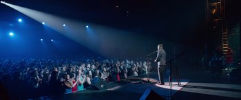 Movie still from “Clouds” (2020), directed by Justin Baldoni – A crowd of people watching a man on a stage; Extreme Wide shot, High angle
