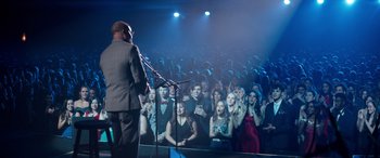 Movie still from “Clouds” (2020), directed by Justin Baldoni – A crowd of people in front of a microphone on a stage; Wide shot, Over the shoulder angle