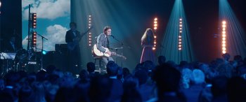 Movie still from “Clouds” (2020), directed by Justin Baldoni – A man sitting on top of a chair while holding a guitar; Wide shot, Over the shoulder angle