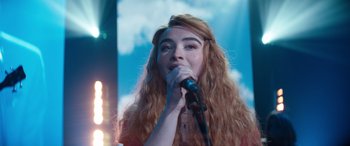 Movie still from “Clouds” (2020), directed by Justin Baldoni – A woman with long red hair is singing into a microphone; Close Up shot, Low angle
