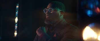 Movie still from “Clouds” (2020), directed by Justin Baldoni – A man with a beard wearing glasses and a suit; Close Up shot, Low angle