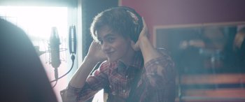 Movie still from “Clouds” (2020), directed by Justin Baldoni – A young man wearing headphones while sitting in a chair; Close Up shot, Over the shoulder angle