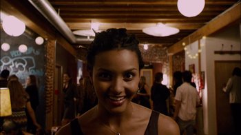 Movie still from “Cloverfield” (2008), directed by Matt Reeves – A woman smiling for the camera in a hallway; Close Up shot, Over the shoulder angle