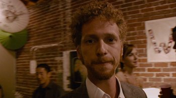 Movie still from “Cloverfield” (2008), directed by Matt Reeves – A person wearing a suit and tie; Close Up shot, Over the shoulder angle