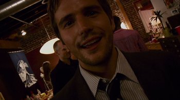 Movie still from “Cloverfield” (2008), directed by Matt Reeves – A person wearing a suit and tie; Close Up shot, Over the shoulder angle