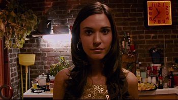 Movie still from “Cloverfield” (2008), directed by Matt Reeves – A beautiful young lady wearing a gold dress; Close Up shot, Low angle