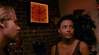 Movie still from “Cloverfield” (2008), directed by Matt Reeves – A woman standing in front of a brick wall with an illuminated clock; Close Up shot, Low angle