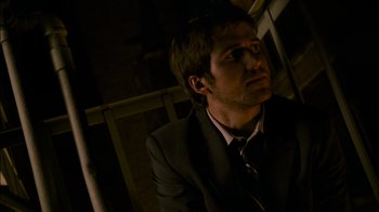 Movie still from “Cloverfield” (2008), directed by Matt Reeves – A man wearing a suit and tie looking up; Close Up shot, Low angle
