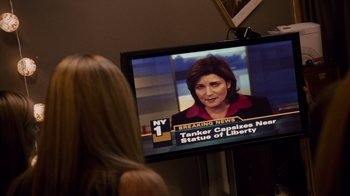 Movie still from “Cloverfield” (2008), directed by Matt Reeves – A woman sitting in front of a television; Close Up shot, Over the shoulder angle