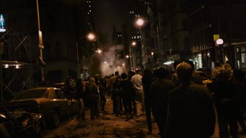 Movie still from “Cloverfield” (2008), directed by Matt Reeves – A group of people walking down a street at night; Wide shot, High angle
