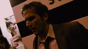 Movie still from “Cloverfield” (2008), directed by Matt Reeves – A person wearing a suit and tie; Close Up shot, Low angle