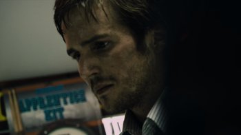 Movie still from “Cloverfield” (2008), directed by Matt Reeves – A person wearing a suit and tie; Close Up shot, Low angle