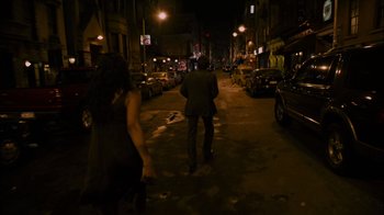Movie still from “Cloverfield” (2008), directed by Matt Reeves – A man and a woman walking down a street at night; Wide shot, High angle